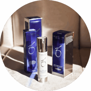 Butelka serum z metaliczną pompką i logo ZO Skin Health ustawiona na jasnym materiale przed trzema pionowymi, połyskującymi niebieskimi opakowaniami kosmetyków w ciepłym świetle z wyraźnymi cieniami.